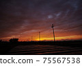 Silhouette of utility poles connected to the sunset sky 75567538