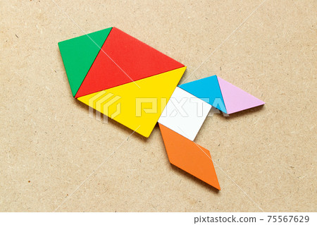 Color tangram puzzle in missile or rocket shape on wood background Color tangram puzzle in missile or rocket shape on wood background 75567629