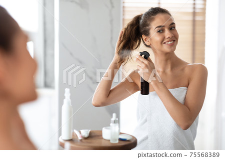 Woman Styling Hair Spraying Hairspray For Repair In Modern Bathroom 75568389