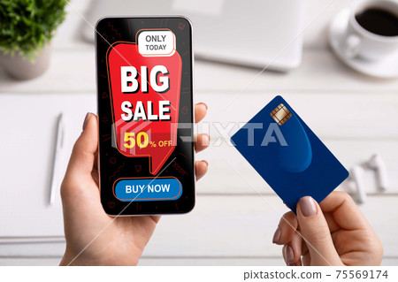Female hands holding phone with shopping screen and credit card Female hands holding phone with shopping screen and credit card 75569174