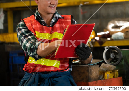 Manufacturing worker working with clipboard to do job procedure checklist . 75569200
