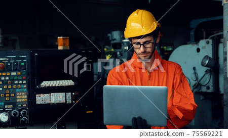 Skillful factory worker working with laptop computer to do procedure checklist . Skillful factory worker working with laptop computer to do procedure checklist . 75569221