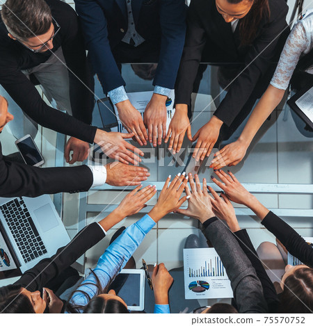 top view. business team joining their hands in a circle top view. business team joining their hands in a circle 75570752