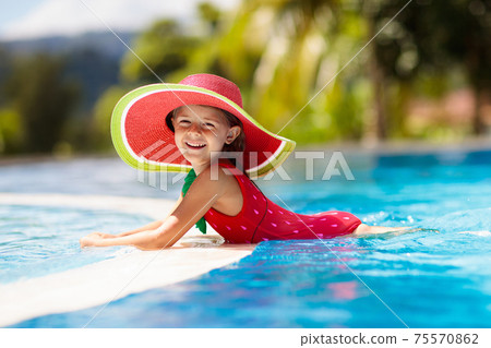 Child with hat in swimming pool. Tropical vacation 75570862