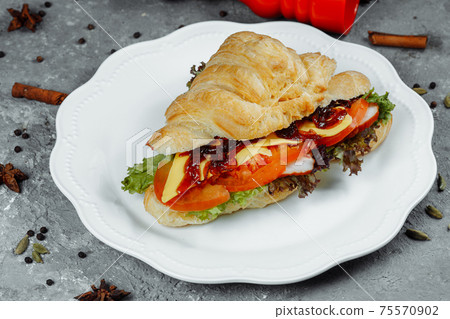 Delicious ham and cheddar cheese croissant with salad Delicious ham and cheddar cheese croissant with salad 75570902