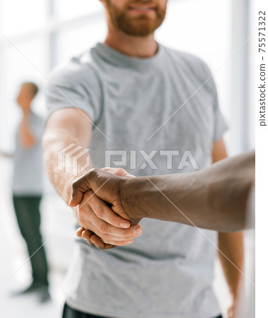 close up. successful young people shaking hands. 75571322