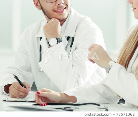doctors colleagues talking sitting at a table in the office 75571368