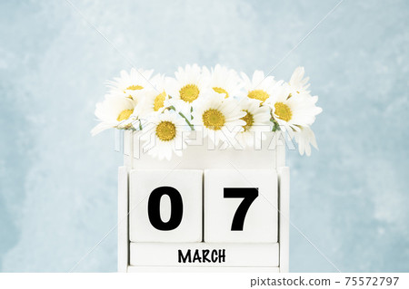 cube calendar for March with daisy flowers over blue with copy space cube calendar for March with daisy flowers over blue with copy space 75572797