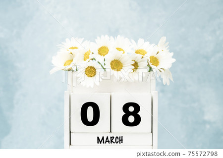 cube calendar for March with daisy flowers over blue with copy space cube calendar for March with daisy flowers over blue with copy space 75572798