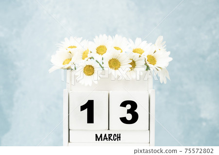 cube calendar for March with daisy flowers over blue with copy space cube calendar for March with daisy flowers over blue with copy space 75572802