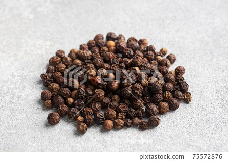 Black pepper peas on a gray concrete background, copy space. 75572876