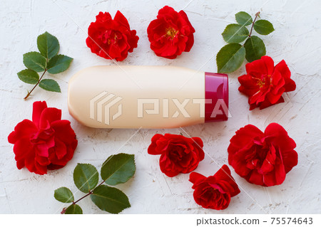 Women perfumers and cosmetics with flowers on a white background. Women perfumers and cosmetics with flowers on a white background. 75574643