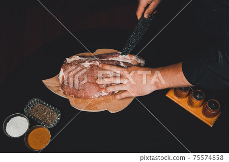 Raw meat, pork neck, the cook prepares the meat for marinating, cuts the lard. Raw meat, pork neck, the cook prepares the meat for marinating, cuts the lard. 75574858