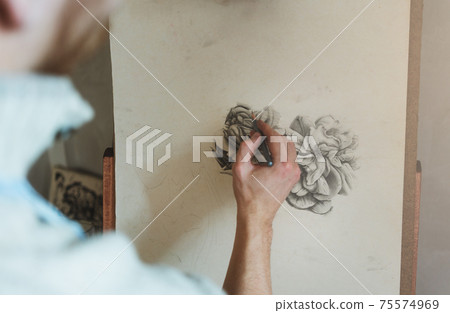 Close-up of hand sketching flower Close-up of hand sketching flower 75574969