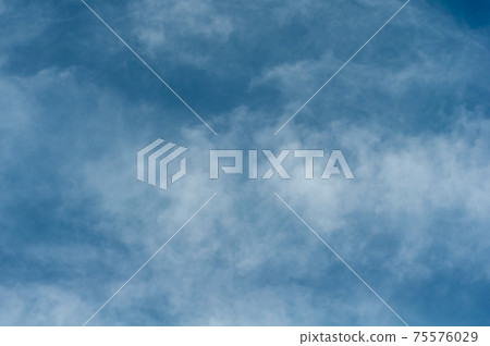 Reflections warm rays setting sun, swirls strong gust wind, outdoors. Bright blue sky, white translucent feathery clouds. Reflections warm rays setting sun, swirls strong gust wind, outdoors. Bright blue sky, white translucent feathery clouds. 75576029