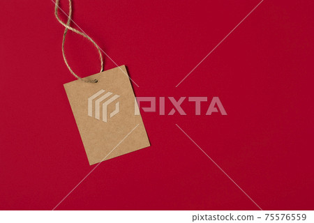 Craft brown paper tag isolated on red background. Sale price banner with copy space in minimal style. Craft brown paper tag isolated on red background. Sale price banner with copy space in minimal style. 75576559