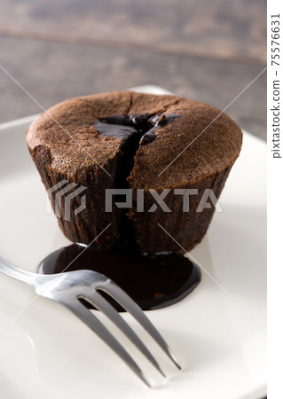 Coulant chocolate cake on wooden table Coulant chocolate cake on wooden table 75576631