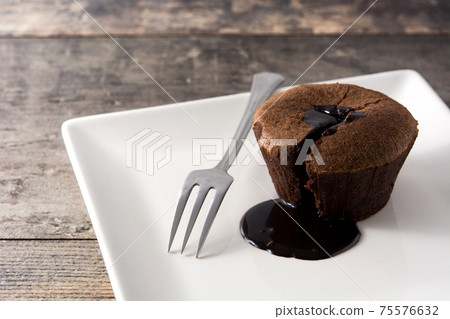 Coulant chocolate cake on wooden table Coulant chocolate cake on wooden table 75576632