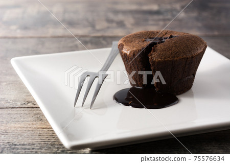 Coulant chocolate cake on wooden table Coulant chocolate cake on wooden table 75576634