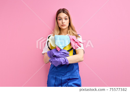 frightened woman with bucket and rags stands, does not know what to do with mess and dirt 75577382