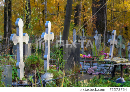 Two silvery grave crosses in the Orthodox Christian cemetery. side view. cloudy autumn day. graveyard landscape Two silvery grave crosses in the Orthodox Christian cemetery. side view. cloudy autumn day. graveyard landscape 75578764