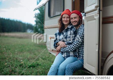 Romantic couple spending time together near trailer home Romantic couple spending time together near trailer home 75580582