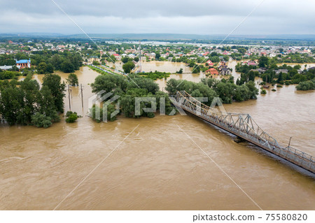 Aerial view of flooded houses with dirty water of Dnister river in Halych town, western Ukraine. Aerial view of flooded houses with dirty water of Dnister river in Halych town, western Ukraine. 75580820