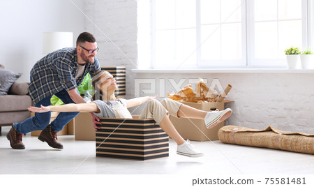 Cheerful couple having fun in new apartment Cheerful couple having fun in new apartment 75581481