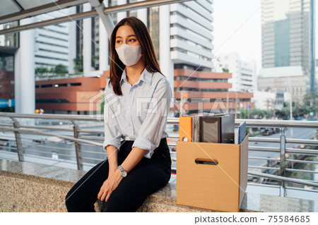 Depressed woman with mask lost job sitting with box of items Depressed woman with mask lost job sitting with box of items 75584685
