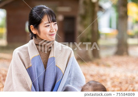 A woman talking to her mom friend in the autumn park A woman talking to her mom friend in the autumn park 75584809