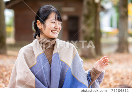 A woman talking to her mom friend in the autumn park A woman talking to her mom friend in the autumn park 75584811