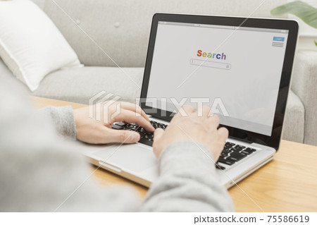 A man searching the internet on a computer 75586619