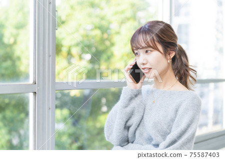 一個女人在窗邊打個電話商業場景 一個女人在窗邊打個電話商業場景 75587403