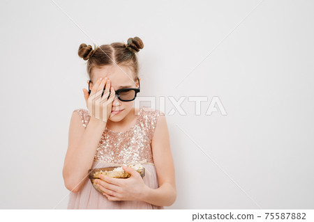 teen girl with glasses to watch scary 3D movies with popcorn against white wall teen girl with glasses to watch scary 3D movies with popcorn against white wall 75587882