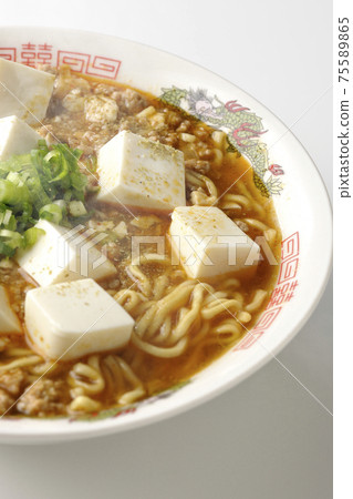 熱麻婆豆腐拉麵和日本胡椒粉，有很多在白色背景上採取的多用途洋蔥 75589865