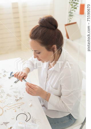 Professional jewelry designer making handmade jewelry in studio workshop. Fashion, creativity and handmade concept Professional jewelry designer making handmade jewelry in studio workshop. Fashion, creativity and handmade concept 75590670