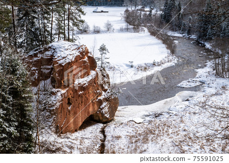 Zvartas red rock and river Amata at city Cesis in Latvia. Winter photo Zvartas red rock and river Amata at city Cesis in Latvia. Winter photo 75591025