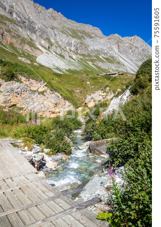 Mountain river and wood bridge in Vanoise national Park valley, French alps Mountain river and wood bridge in Vanoise national Park valley, French alps 75591605