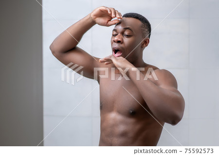African american sporty guy looking sleepy and stretching African american sporty guy looking sleepy and stretching 75592573