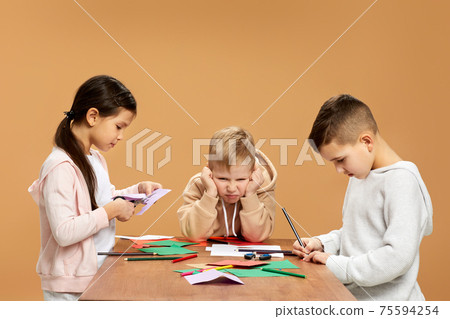 happy children cutting colored papers with scissors 75594254