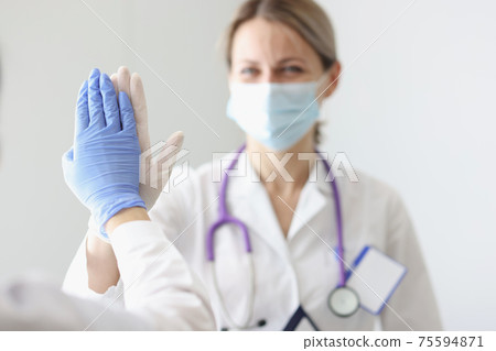 Two doctors in protective masks and gloves give each other five Two doctors in protective masks and gloves give each other five 75594871