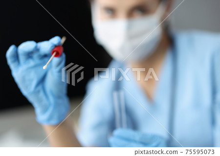 Doctor in medical protective mask holds shelf with test tube for sampling biological material 75595073