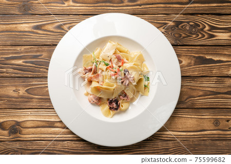 Pappardelle pasta with octopus and bacon Pappardelle pasta with octopus and bacon 75599682