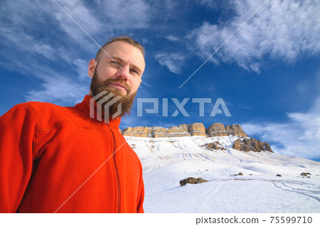 cheerful man with a beard smiles on a background of mountains cheerful man with a beard smiles on a background of mountains 75599710