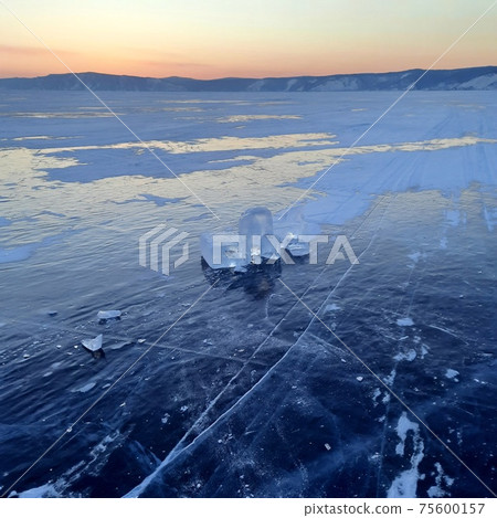 Winter Russian Baikal tourism.Beautiful crack that goes beyond the horizon on the ice of lake Baikal. Winter Russian Baikal tourism.Beautiful crack that goes beyond the horizon on the ice of lake Baikal. 75600157