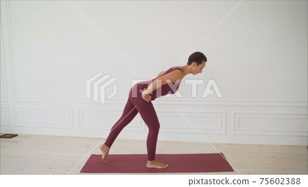 Sporty millennial people training together in fitness studio, perform squats exercises on mats, female instructor or coach teach athletes do workouts, show techniques in gym. Healthy hobby concept Sporty millennial people training together in fitness studio, perform squats exercises on mats, female instructor or coach teach athletes do workouts, show techniques in gym. Healthy hobby concept 75602388