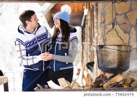 Family in love laughing and cooking in the winter outdoors. Bonfire, barbecue, bowler. Family in love laughing and cooking in the winter outdoors. Bonfire, barbecue, bowler. 75602474