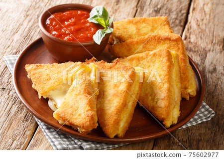 Mozzarella in Carrozza sandwich gets an extra dose of richness from a creamy egg bath and is coated in breadcrumbs for extra crunch closeup in the plate. horizontal Mozzarella in Carrozza sandwich gets an extra dose of richness from a creamy egg bath and is coated in breadcrumbs for extra crunch closeup in the plate. horizontal 75602977