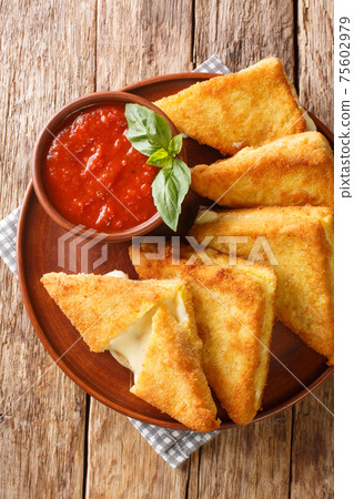 Mozzarella in Carrozza Fried Italian Sandwiches with sauce closeup in the plate. Vertical top view Mozzarella in Carrozza Fried Italian Sandwiches with sauce closeup in the plate. Vertical top view 75602979
