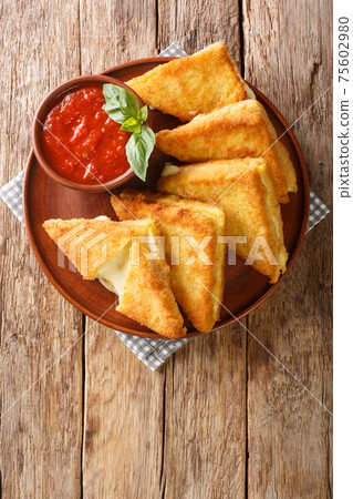 Hot fried sandwiches with mozzarella cheese close-up in a plate. vertical top view Hot fried sandwiches with mozzarella cheese close-up in a plate. vertical top view 75602980